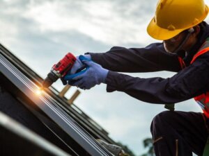 contractor drilling metal roof panel for roofing license